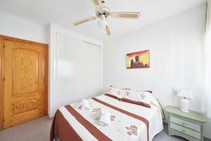 ein Schlafzimmer mit einem Bett und einem Deckenventilator in der Unterkunft Apartamento Cala Higuera 80m2 in San José