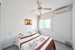ein weißes Schlafzimmer mit einem Bett und einem Deckenventilator in der Unterkunft Apartamento Cala Higuera 80m2 in San José