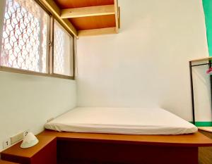 Bett in einem Zimmer mit Fenster in der Unterkunft 澎湖北吉光背包客民宿 Bayhouse Hostel Penghu in Magong