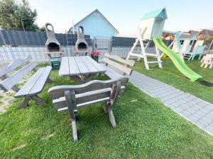 a park with benches and a table and a playground at Domki Kalipso in Sarbinowo
