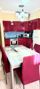 Apartment With Pool Gozo في غاينسييليم: مطبخ مع طاولة خشبية ودواليب حمراء