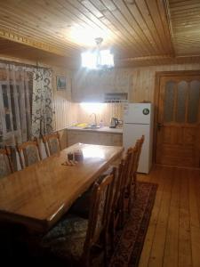 マイコリチンにあるHoliday Home Tihiy Dvorのキッチン(大きな木製テーブル、冷蔵庫付)