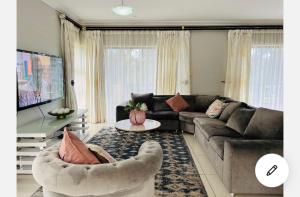 a living room with a couch and a table at Ndaba Golf Lodge on 13th hole in East London