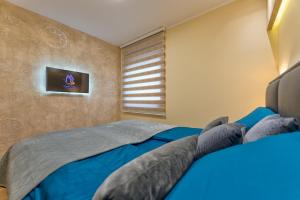 a bedroom with a blue bed and a television at Apartment Papillon 5 in Zlatibor