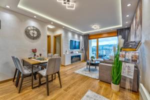 a dining room and living room with a table and chairs at Apartment Papillon 5 in Zlatibor