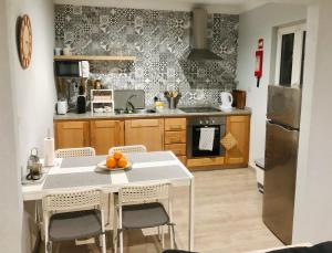 a kitchen with a white table and chairs in it at Casa Nunes in Pinhão