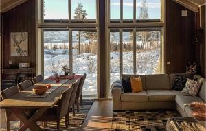 een woonkamer met een tafel en een bank bij Amazing Home In Brttum With House A Panoramic View in Skrukkerud
