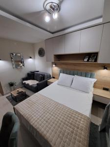 a bedroom with a large white bed and a couch at Lux apartmani Dunja Kopaonik Čardaci - GREEN in Kopaonik