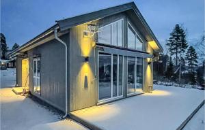 a house with a lot of windows in the snow at Amazing Home In Brttum With House A Panoramic View in Skrukkerud