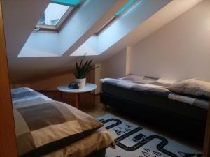 a attic room with two beds and a window at Leśny Loft in Gdynia