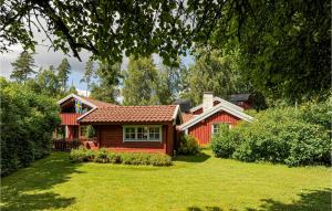 uma casa vermelha num quintal com um relvado verde em 3 Bedroom Cozy Home In Hillared em Hillared