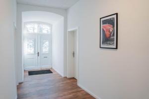 un couloir vide avec des murs blancs et une photo sur le mur dans l'établissement Buer Appartment, à Gelsenkirchen
