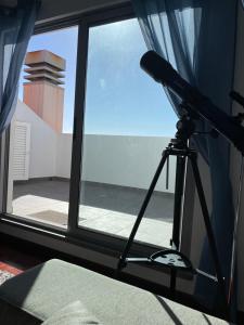 a camera on a tripod in front of a window at Penthouse Palmeira in Gaula