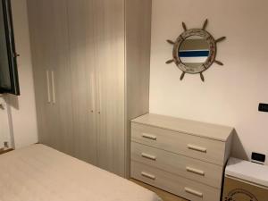 a bedroom with a bed and a dresser and a mirror at Iseo Lake apartment in Sulzano
