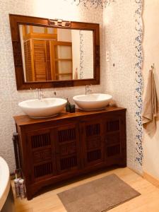 La salle de bains est pourvue de 2 lavabos et d'un miroir. dans l'établissement Chaîne des puys chez William, à Royat