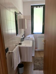 a bathroom with a white sink and a window at Iseo Lake apartment in Sulzano +12 photos