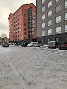 un parking avec des voitures garées devant les bâtiments dans l'établissement New apartment, two bed room, free car park, à Turku