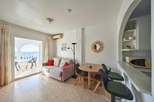 a living room with a couch and a table and chairs at Apartamento Balcón de San José, piscina, parking in San José