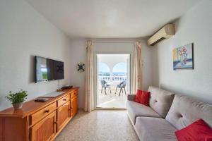 a living room with a couch and a tv at Apartamento Balcón de San José, piscina, parking in San José