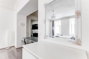 La salle de bains blanche est pourvue d'un miroir et d'un lavabo. dans l'établissement Lovely Apartments Heart of Prague, à Prague