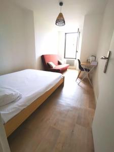 - une chambre avec un lit, une chaise et une table dans l'établissement Maison 2 chambres, 6 pers - Wifi et Linge inclus - Niort centre, à Niort