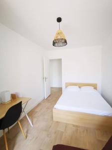 - une chambre avec un lit, un bureau et une chaise dans l'établissement Maison 2 chambres, 6 pers - Wifi et Linge inclus - Niort centre, à Niort