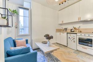 a living room with a blue couch and a table at Joli appartement bois de Vincennes, metro 1, rer A in Vincennes