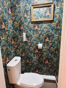 a bathroom with a toilet and a flower wallpaper at Joli appartement bois de Vincennes, metro 1, rer A in Vincennes