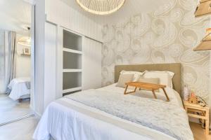 a bedroom with a bed with a wooden table on it at Joli appartement bois de Vincennes, metro 1, rer A in Vincennes