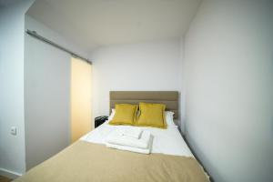 1 dormitorio con 1 cama con 2 almohadas amarillas en Apartamentos do Corgo en Vila Real