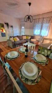 a wooden table with plates and a bottle of wine at Apartman Noa in Jušići