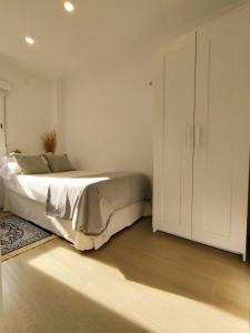 - une chambre avec un lit et une armoire blanche dans l'établissement Casa La Victoria, à Malaga