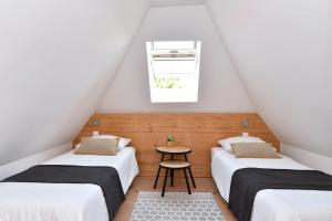 a attic bedroom with two beds and a table at Magnifique Gite Le Clos des pierres Route des Vins d'Alsace in Beblenheim