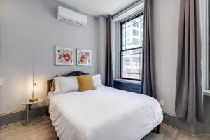 1 dormitorio con cama blanca y ventana en Alina & Fanny - Philadelphia Northern Liberties, en Filadelfia