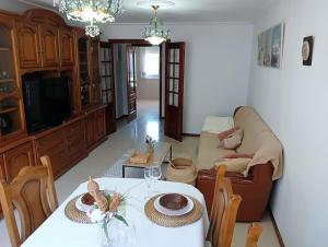 ein Wohnzimmer mit Tisch und Couch in der Unterkunft Piso A Capela con vistas al mar in Fisterra