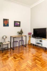 uma sala de estar com piso em madeira e uma televisão em Hotel Mama! Copacabana (Posto1 -Leme) no Rio de Janeiro