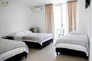 1 dormitorio con 2 camas y ventana grande en Centro Vacacional Las Palmas, en San José del Guaviare