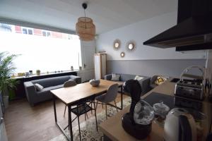 uma sala de estar com uma mesa e um sofá em La Maison du Bonheur - Lille em Lille