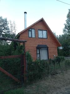 una casa con una valla delante de ella en Cabaña Coñaripe, en Coñaripe