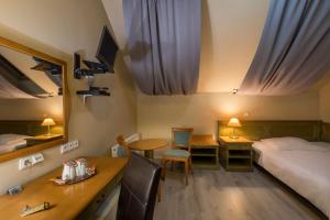 a hotel room with a bed and a desk and a table at Augustus et Otto Hotel in Prague