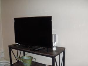 a tv sitting on a table with a speaker and a speaker at Aux vieux fours in Noaillac