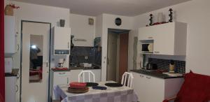 a kitchen with white cabinets and a table in it at Joli Studio centre ville Digne les Bains Galion 80 in Digne-les-Bains