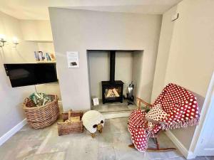 a living room with a fireplace and a tv at *Brecon Beacons,Log Burner, hot tub Dogs Welcome* in Crickhowell