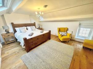 a bedroom with a large bed and a yellow chair at *Brecon Beacons,Log Burner, hot tub Dogs Welcome* in Crickhowell