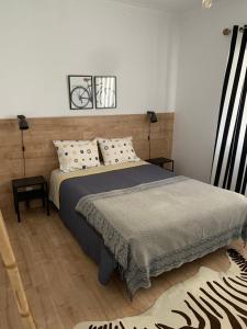 1 dormitorio con 1 cama, 2 lámparas y 1 alfombra en Casa do Pai Castelo de Bode, en Serra