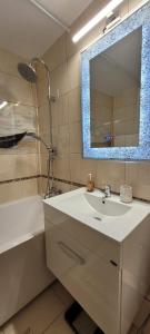 a bathroom with a sink and a mirror and a tub at Brancoveanu Apartament's in Bucharest
