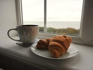 a pastry on a plate next to a window at Coastguard Lookout in Hunstanton