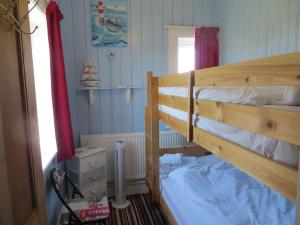 een slaapkamer met een stapelbed en een raam bij Coastguard Lookout in Hunstanton