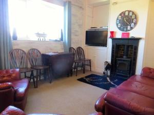 a living room with a table and chairs and a fireplace at Coastguard Lookout in Hunstanton