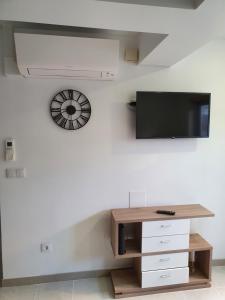 - un salon avec une télévision sur un mur blanc dans l'établissement Holidays House, à São Martinho do Porto